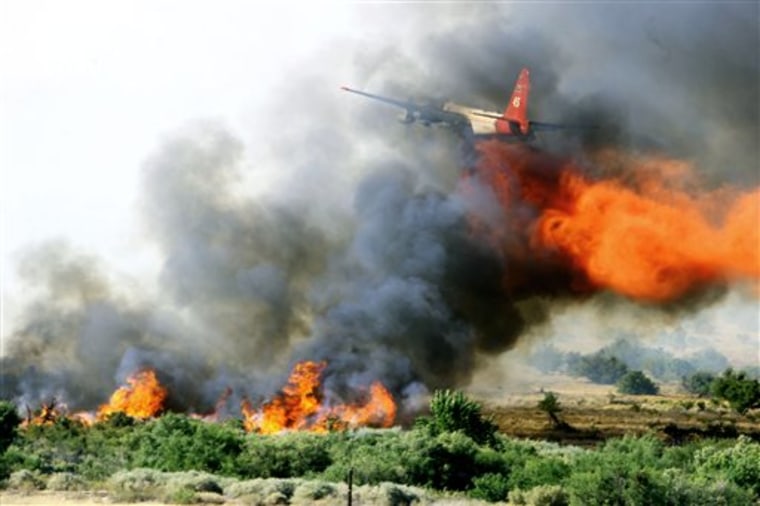A tanker plane drops fire retardant over a fire near Moapa National Wildlife Refuge, northeast of Las Vegas, on Thursday. 